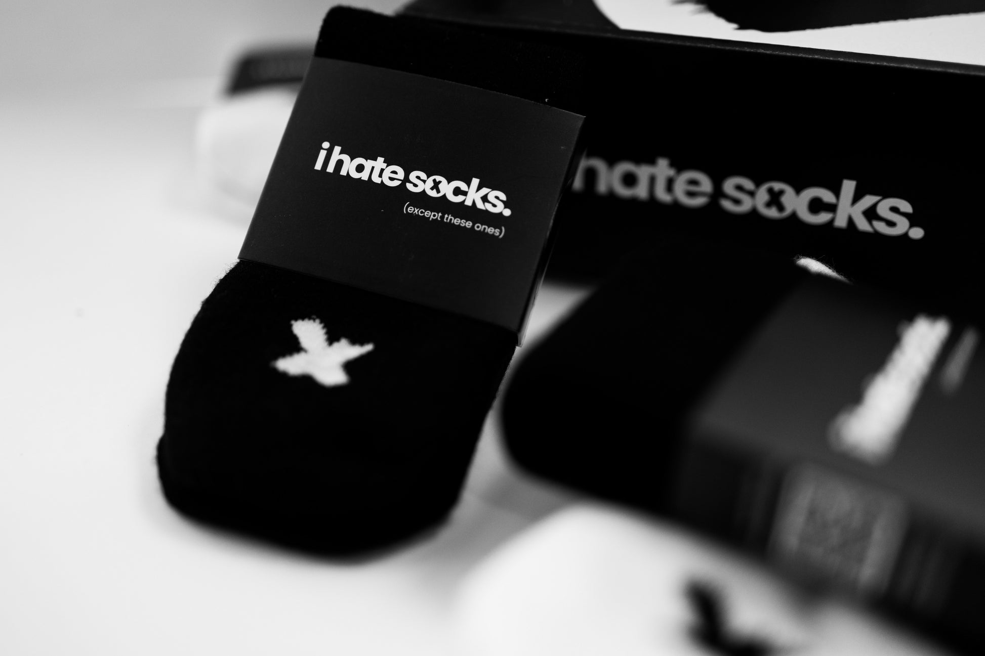 close up of black seamless socks with branding 'i hate socks- except these ones'