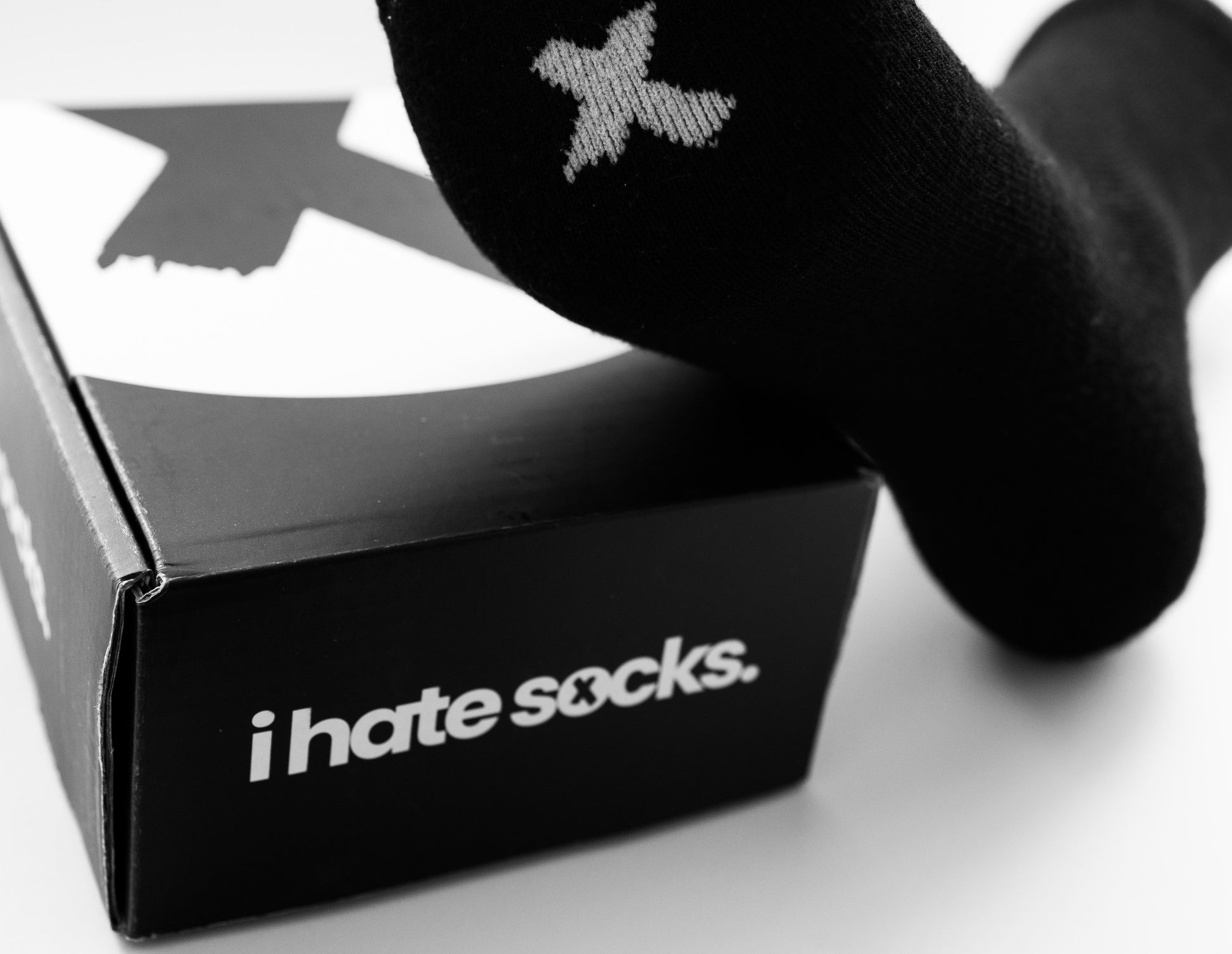 Black bamboo sock with a logo and 'i hate socks' box on a white background