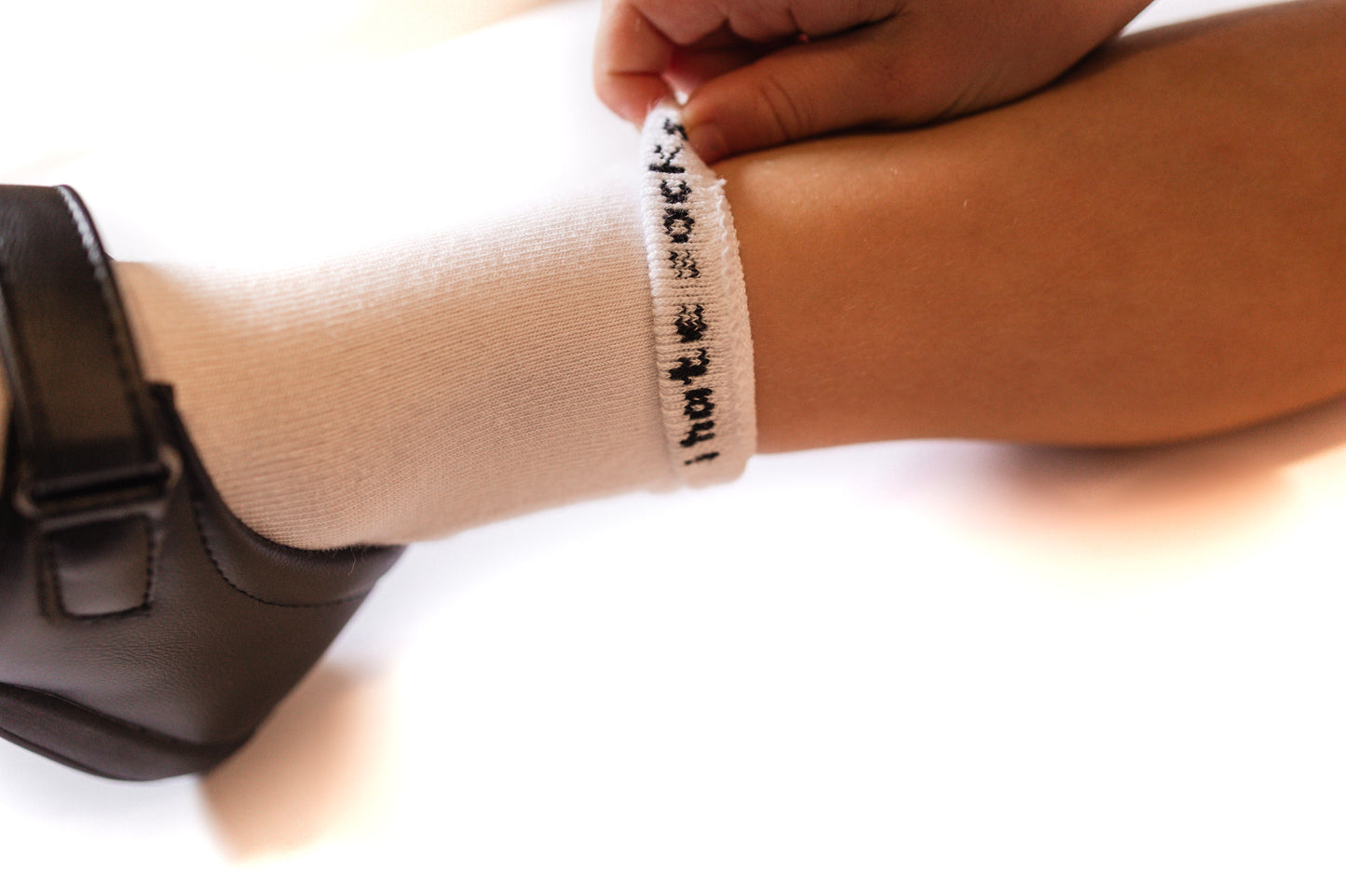 Close-up of the inside of a sock welt saying 'i hate socks'. A hidden message for the brand "i hate socks' for children with sensory issues regarding clothing.