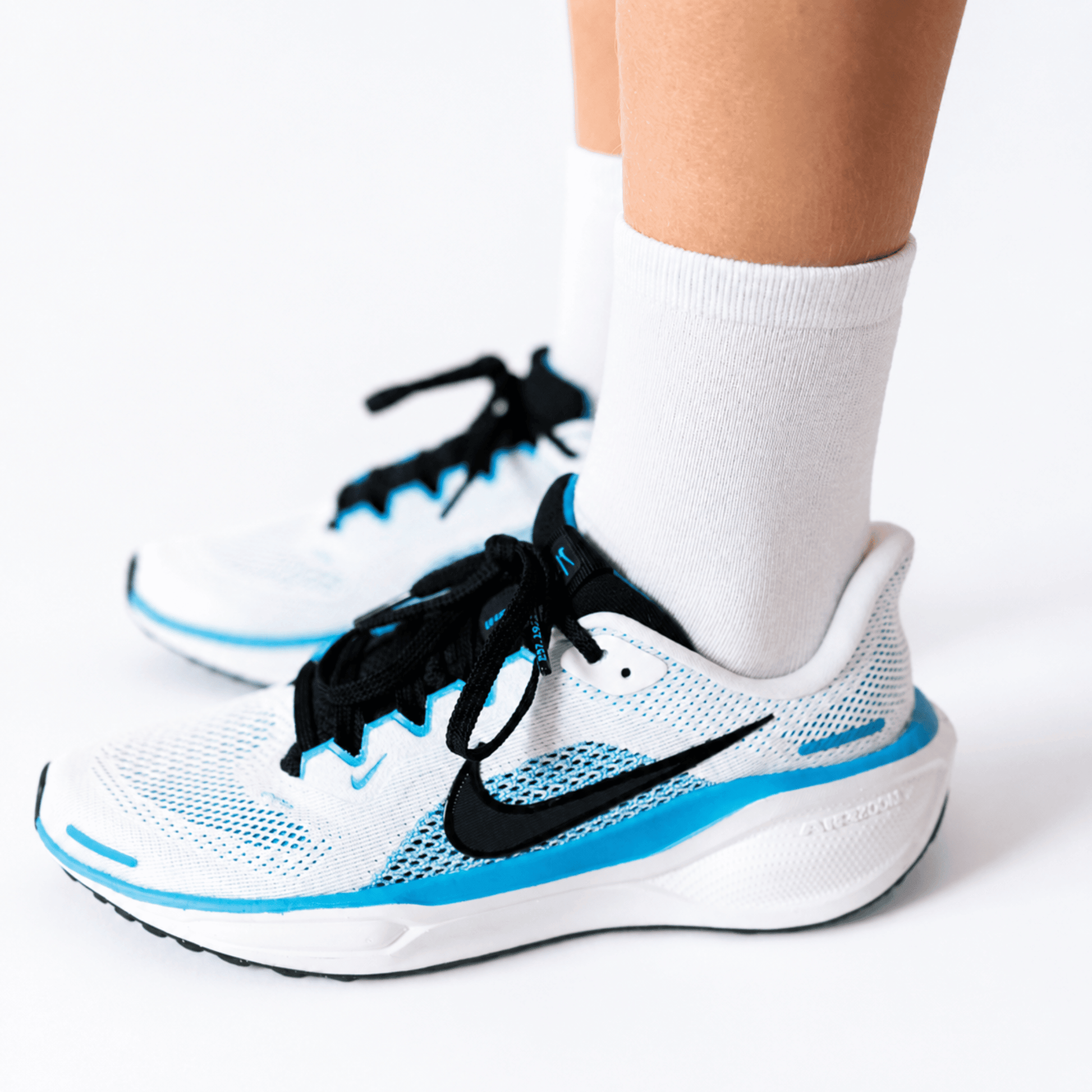 Child wearing white seamless-feel seam free socks with white sports shoes